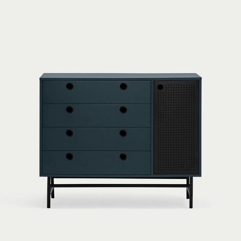 La Cómoda en MDF con 4 Cajones y Puerta en Metal Punto 1P4C es una cómoda azul oscuro con cuatro cajones y una puerta de metal perforado, sobre patas negras, ideal para el almacenaje moderno. Su diseño industrial-contemporáneo realza cualquier estancia.