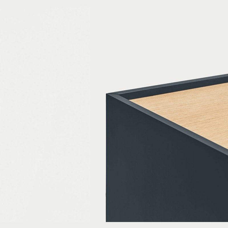 Una mesa minimalista de bordes cuadrados en madera y negro sobre un fondo blanco resalta el diseño moderno. Su estilo versátil recuerda a la Cómoda en MDF y Roble con 3 Cajones y Puerta Otto 1P3C, que se integra a la perfección en cualquier espacio contemporáneo.