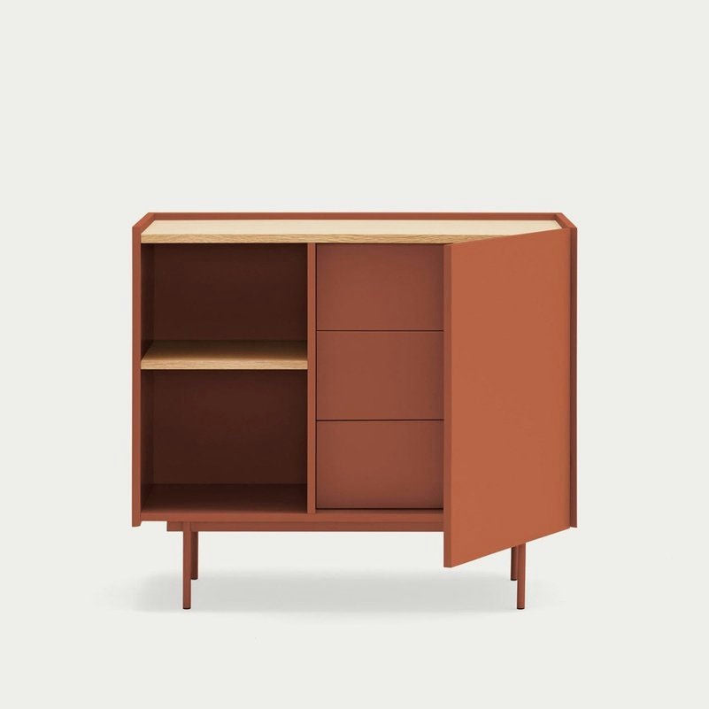 La Cómoda en MDF y Roble Otto 1P3C de color marrón rojizo combina un diseño moderno con un diseño versátil de tres cajones y una puerta abierta que revela estantes en el lado derecho, mostrando estilo y funcionalidad.