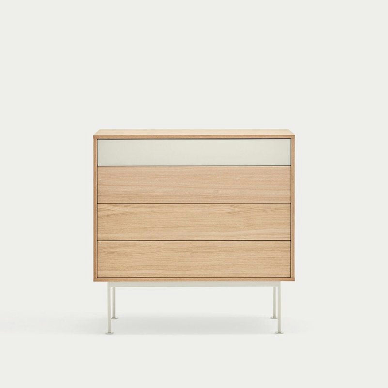 La cómoda Yoko 4C de MDF y Roble, con cuatro cajones con un cajón superior blanco y delgadas patas de metal, personifica el almacenamiento contemporáneo sobre un fondo sencillo.