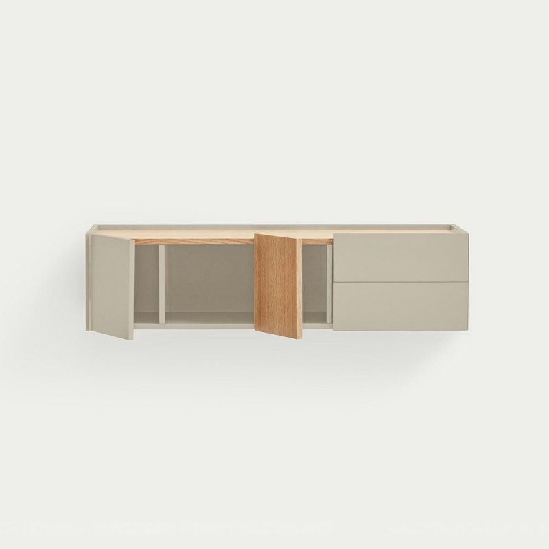 La Consola Otto 2P2C (Suspendida) es un mueble de almacenaje de pared que destaca por su modernidad y funcionalidad, compuesto por dos armarios abiertos y dos cajones cerrados. Su diseño flotante combina un gris claro minimalista con acabado en madera, ideal para espacios contemporáneos.