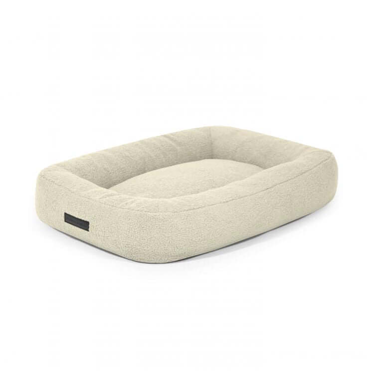 Una cama rectangular de color beige claro para perro de tela borreguito 75×60×18 cm - CAMA PARA PERROS 75 TEDDY con laterales elevados y una superficie de textura suave, ideal para perros, expuesta sobre un fondo blanco.