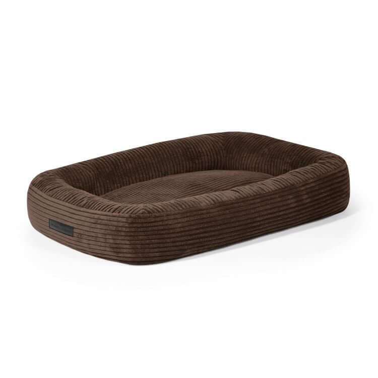 Una cama rectangular marrón para perro de terciopelo acanalado 75×60×18 cm - DOG BED 75 WAVES con bordes en relieve, que se muestra sobre un fondo blanco.