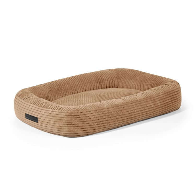 La CAMA PARA PERROS 75 ONDAS es una cama rectangular de pana aterciopelada de color canela (75×60×18 cm) con laterales elevados y superficie plana, que se muestra sobre un fondo blanco liso.