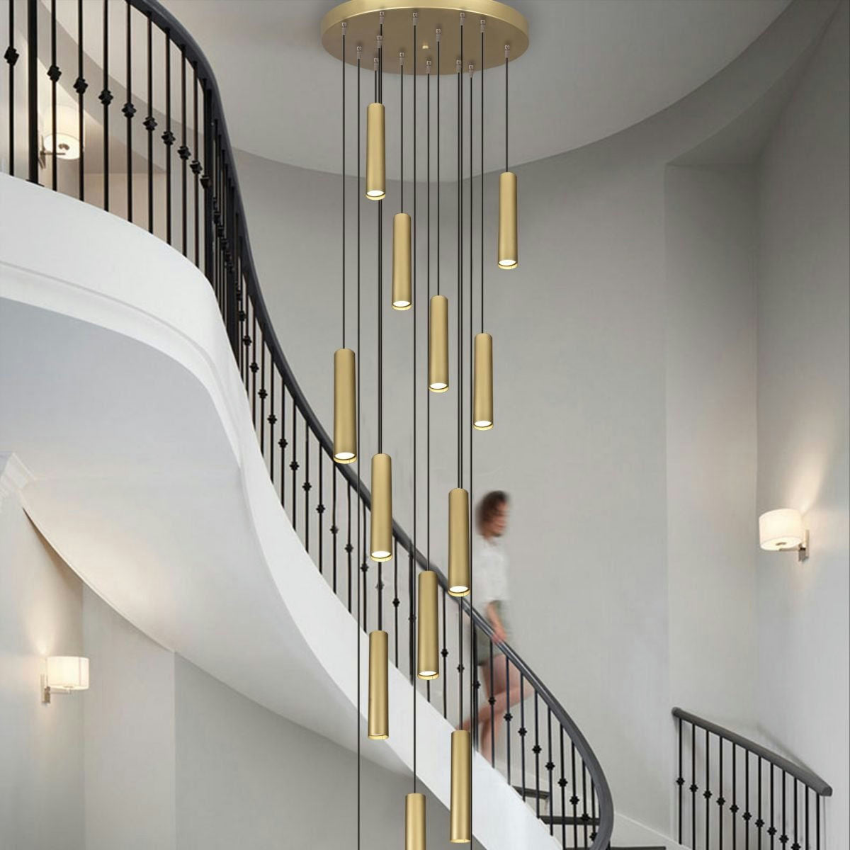 Una escalera de caracol con una mujer en movimiento desciende bajo una lámpara de techo colgante moderna en cascada que presenta la Lámpara de Techo Colgante Moderna de Metal Dorado 3043-14C-30. El interior tiene paredes grises y lámparas de pared que incorporan una estética elegante de diseño moderno.