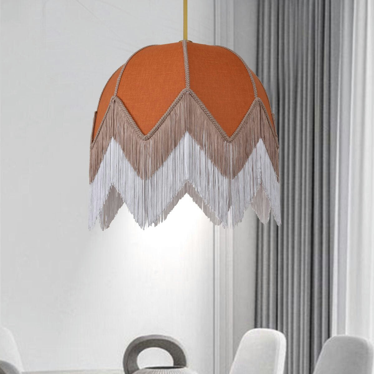 La Lámpara de Techo Colgante Vintage de Flecos Terracota 30160, con su pantalla naranja y flecos en capas, añade un toque de diseño bohemio a un comedor con sillas blancas y cortinas grises.