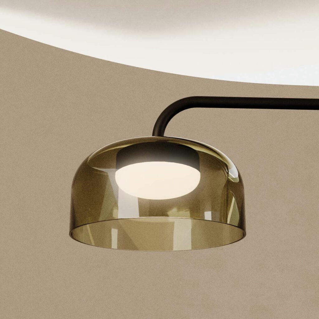 Primer plano de la moderna Lámpara de techo Ipon, de forma de cúpula, con acabado metálico y bombilla visible, que proyecta una iluminación suave sobre un fondo neutro.