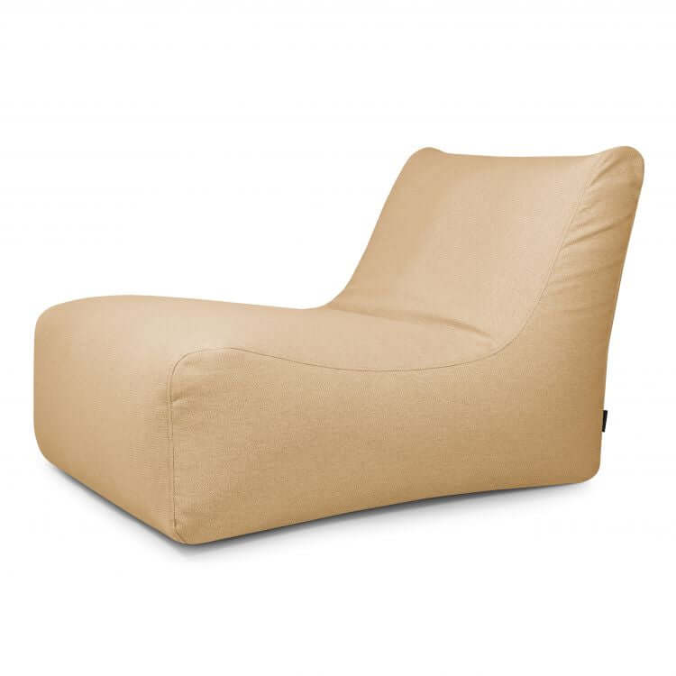 El Bean Bag Lounge 100 Dunes es un sillón moderno de color tostado para exteriores, con un diseño bajo y curvado sin patas visibles e inspirado en los puff de gran formato, que se muestra sobre un fondo blanco liso.