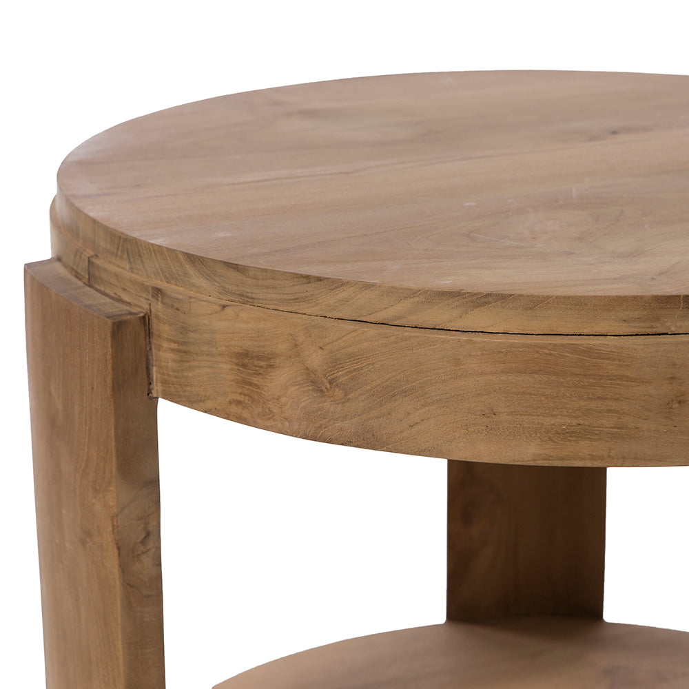 Un primer plano de la Mesa auxiliar Redonda en Madera de teca Nabila Ø60, mostrando su acabado natural, su grueso tablero, sus robustas patas y su compacto diseño redondo.