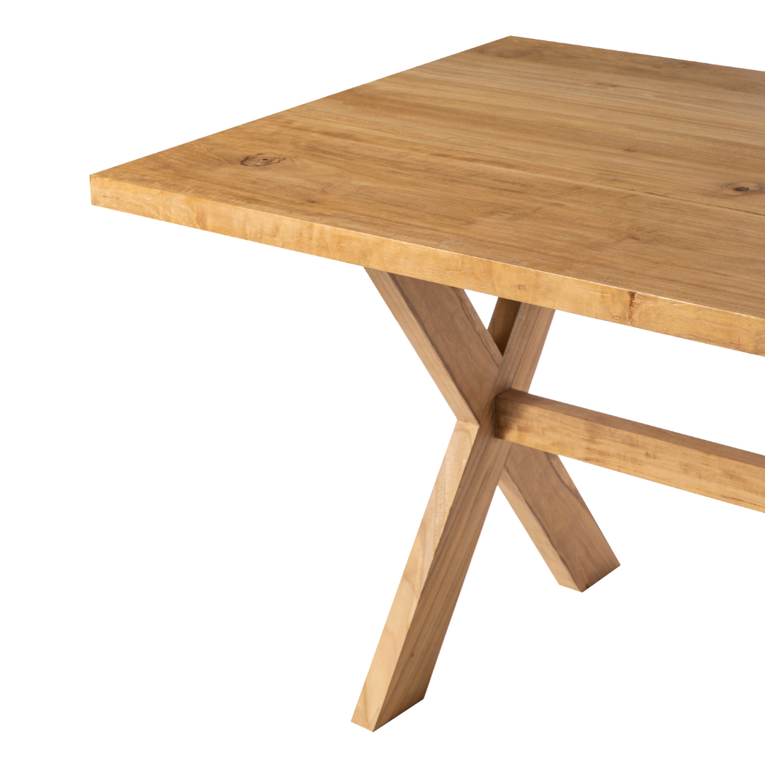 La mesa de comedor en madera de teca Begur presenta un diseño moderno con sus patas en ángulo en forma de X, elaboradas con madera de teca de alta calidad.