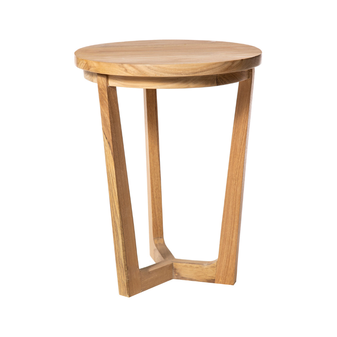 La Mesa auxiliar Redonda en Madera de teca Roman es una mesa redonda pequeña con tres patas anguladas y acabado natural, ideal como mesa auxiliar para sala, presentada sobre un fondo blanco.
