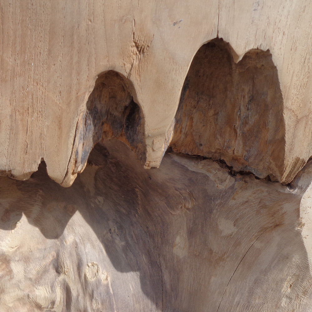 Primer plano del Puff cuadrado de madera natural Erosion, resaltando la madera texturizada con ranuras naturales y patrones de vetas en diferentes tonos de marrón, que recuerdan un exquisito diseño artesanal.