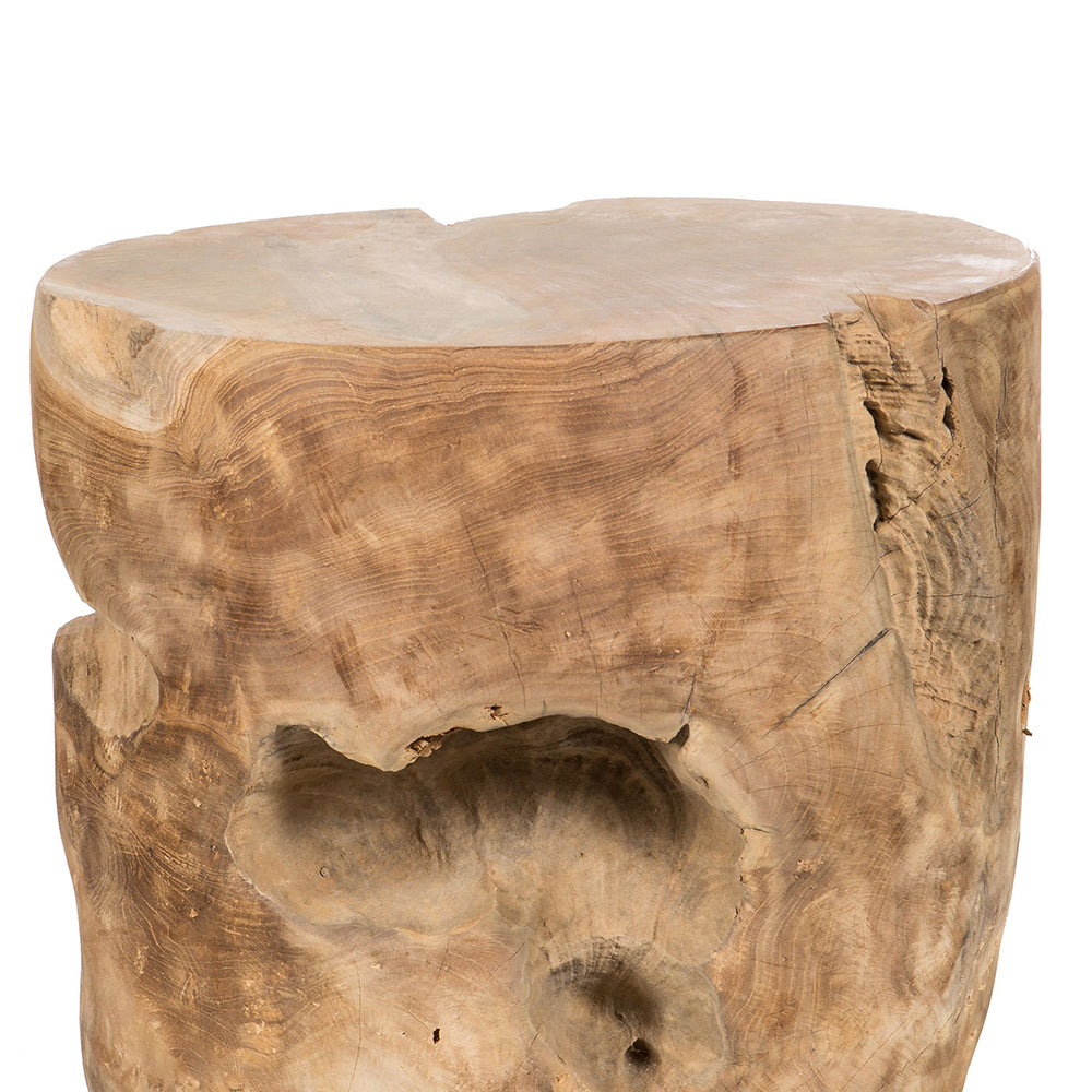 El taburete redondo Puff en madera de teca de Indonesia es natural y rústico, elaborado con madera de teca sin terminar con una superficie rugosa y grietas visibles.