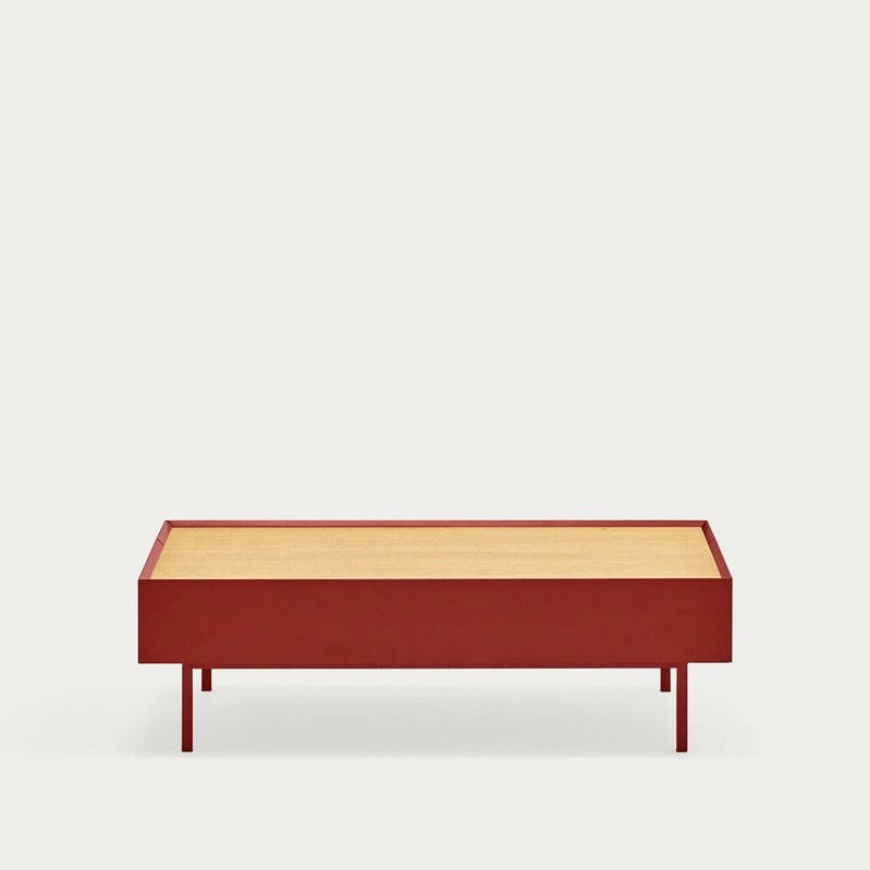 La Mesa de Centro Arista 2C es una mesa de centro minimalista rectangular de color rojo con una tapa de madera clara, que se destaca elegantemente sobre un fondo blanco liso, ideal para cualquier diseño de interiores.