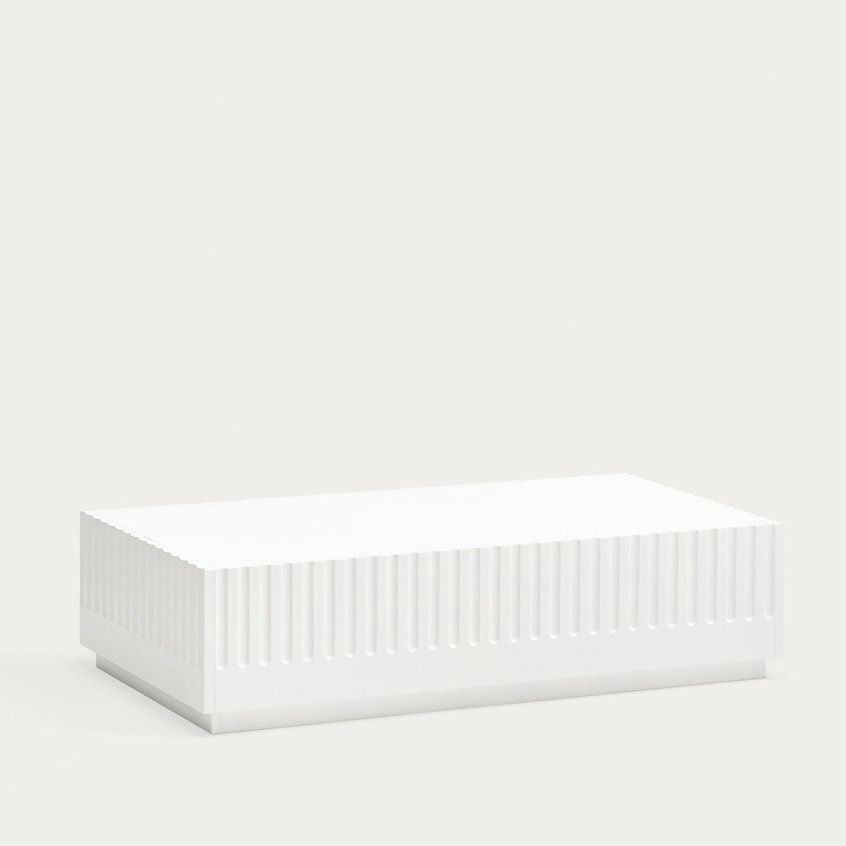 La Mesa de Centro Doric, una caja blanca rectangular con crestas horizontales en los lados que recuerdan al diseño neoclásico, se encuentra sobre un fondo gris claro liso.