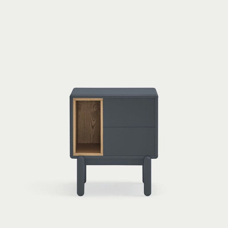 La Mesita de Noche Corvo 2C es una mesita de noche compacta, de color gris oscuro, que presenta un almacenamiento eficiente con dos cajones y un estante de madera abierto sobre patas cortas, mostrando un diseño moderno.