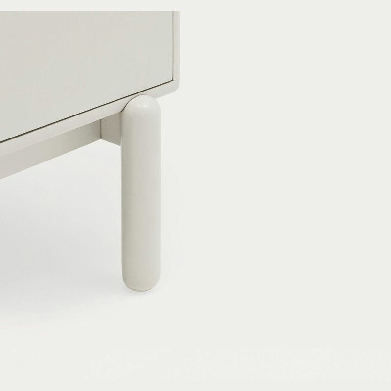 Primer plano de la Mesita de Noche Corvo 2C, un mueble beige que presenta una pata vertical redondeada sobre un fondo claro, resaltando su diseño moderno y almacenamiento eficiente.