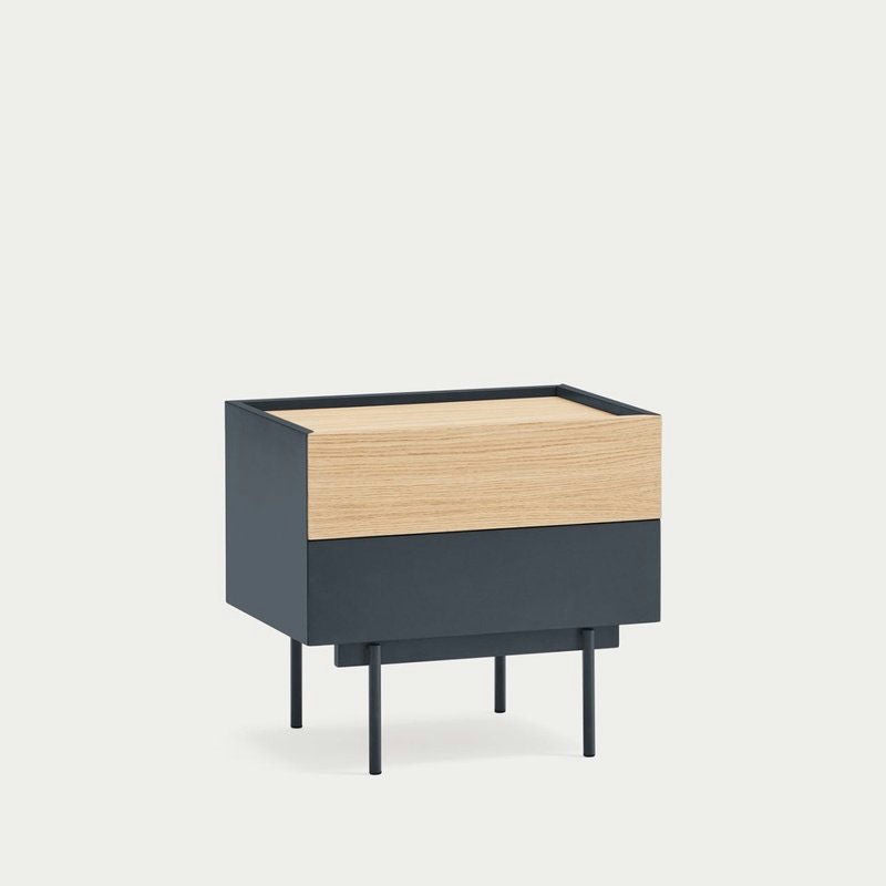 La mesita de noche Otto 2C cuenta con un diseño elegante y moderno con el estilo característico de Cambres Design. Incluye un solo cajón, elaborado en madera y metal negro, complementado por cuatro patas delgadas sobre un fondo liso que le da elegancia.
