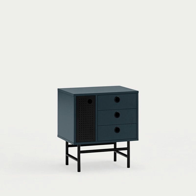 La mesita de noche Punto 1P3C es un pequeño mueble verde oscuro con tres cajones, una puerta con tiradores circulares y cuatro patas negras. Ofrece un amplio espacio de almacenamiento interno y combina estilo y funcionalidad en un diseño contemporáneo sobre un fondo claro.