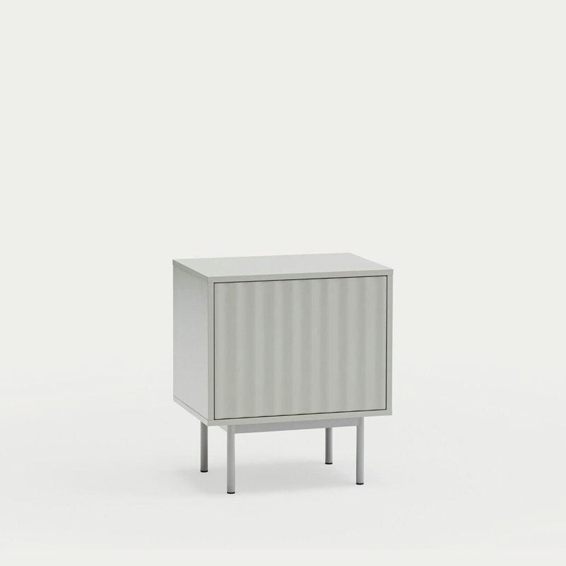 Descubre la Mesita de Noche Sierra 2C de Cambres Design, un mueble de almacenaje compacto en gris claro con un diseño minimalista que cuenta con una puerta. Se alza elegantemente sobre cuatro patas sobre un fondo blanco, ofreciendo una combinación perfecta de estilo y funcionalidad.
