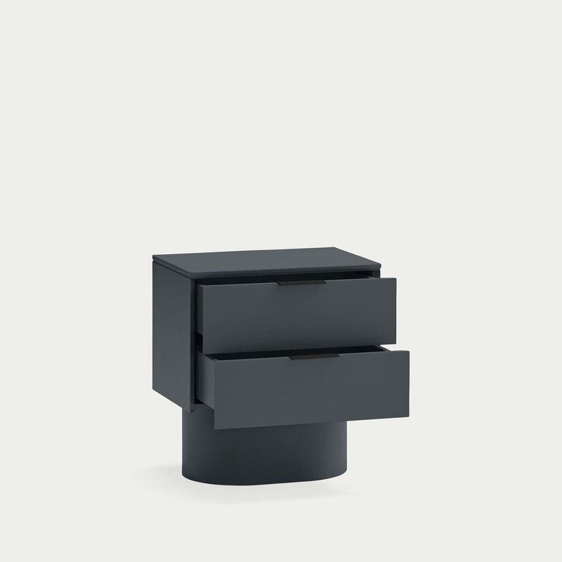 La mesita de noche Totem 2C, una moderna mesita de noche de color oscuro con dos cajones ligeramente abiertos, ejemplifica el almacenamiento minimalista sobre un fondo blanco liso.