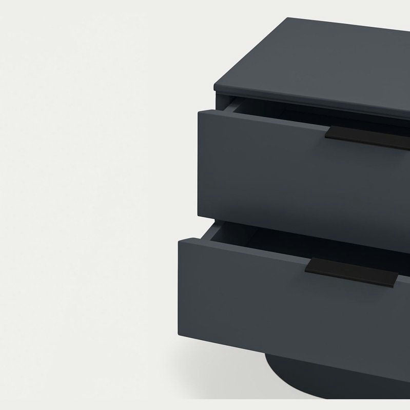 La mesita de noche Totem 2C es un mueble gris oscuro de dos cajones, ambos ligeramente abiertos. Presenta un elegante diseño contemporáneo sobre un fondo claro y es perfecta para el almacenamiento minimalista, ya que funciona como una elegante mesita de noche.