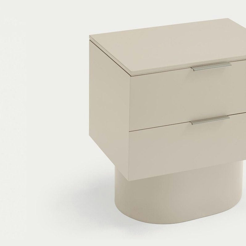 La Mesita de noche Totem 2C, en beige y con diseño contemporáneo, cuenta con dos cajones para ofrecer almacenamiento minimalista. Su base redondeada se destaca elegantemente contra un fondo blanco.
