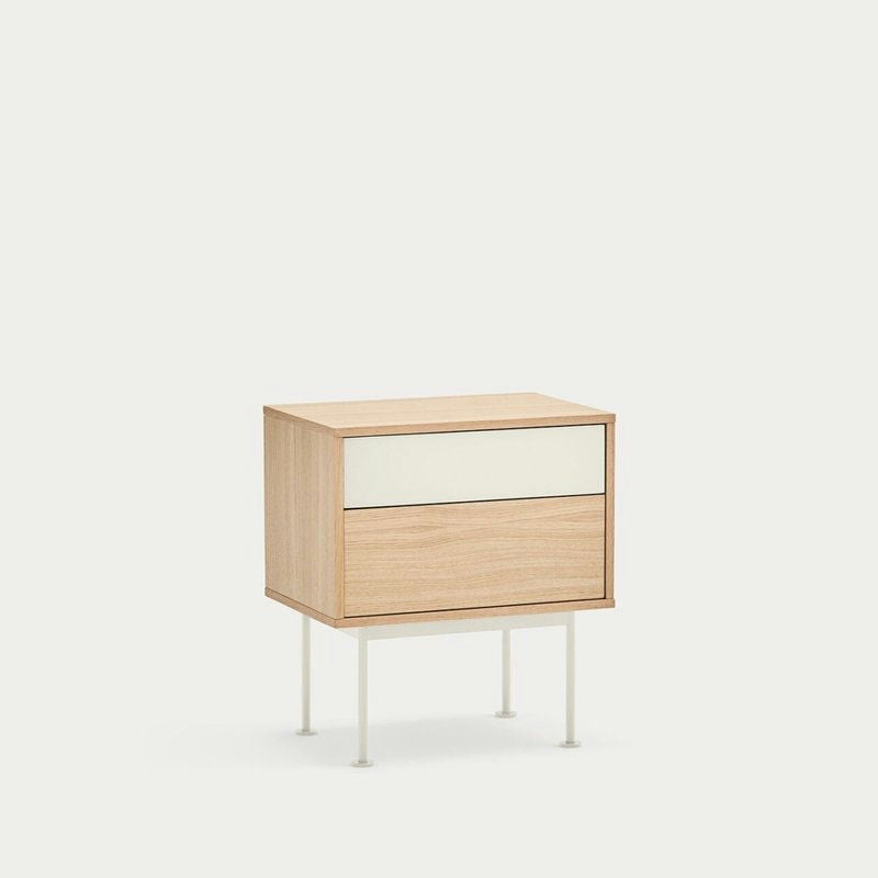 La mesita de noche Yoko 2C de Cambres Design cuenta con dos cajones, una tapa en color crema claro y un cajón inferior en madera a juego, todo ello sobre un fondo blanco liso. Combina a la perfección la elegancia moderna con el estilo contemporáneo.