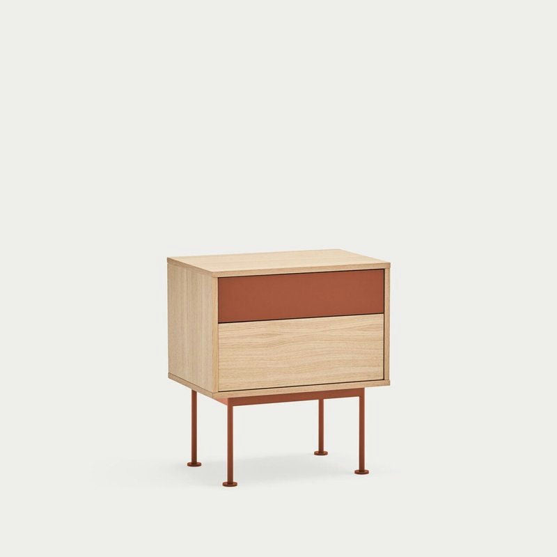 La mesita de noche Yoko 2C de Cambres Design presenta un acabado de madera clara con detalles en color óxido y un diseño contemporáneo, completo con dos cajones sostenidos por cuatro delgadas patas de metal.