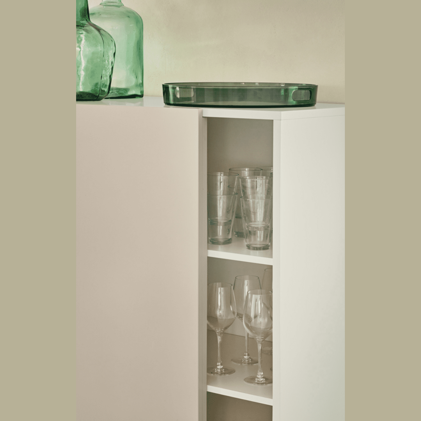 El Aparador con Puerta Corredera y Cajones Nube 1P4C encarna el minimalismo con elegantes estantes para exhibir copas de vidrio y copas de vino. Las botellas de vidrio verde se colocan sobre una elegante bandeja, mientras que su puerta corredera oculta o revela con elegancia su colección.