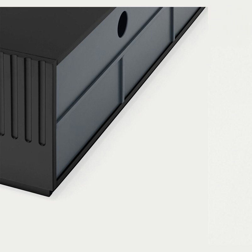 Primer plano de una caja de almacenamiento negra con una abertura circular y ranuras horizontales que refleja un diseño clásico. Refleja la elegancia del Mueble TV Doric 4P2C sobre un fondo claro y sencillo.