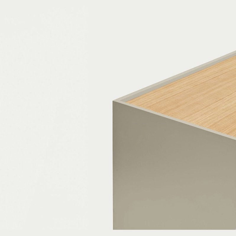 Un rincón minimalista del Mueble TV Otto 2P2C, una mesa de color gris claro y madera sobre un fondo blanco liso, captura la esencia del diseño contemporáneo, combinando estilo y practicidad.