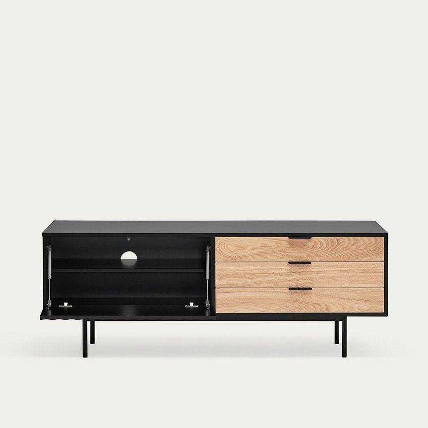El Mueble TV Sierra 1P3C es un mueble de TV moderno con acabado en madera y negro, con elegantes compartimentos, estantes abiertos a la izquierda y tres cajones a la derecha. Su diseño encarna el estilo contemporáneo, sobre un fondo liso.