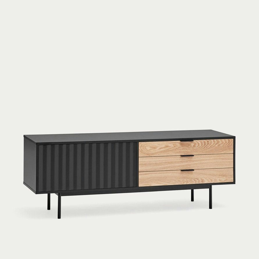 El Mueble TV Sierra 1P3C es un aparador moderno con estructura de metal negro, dos cajones de madera y una puerta corrediza corrugada. Se apoya sobre unas esbeltas patas negras y ofrece un almacenamiento elegante, complementando cualquier espacio con su elegante diseño.