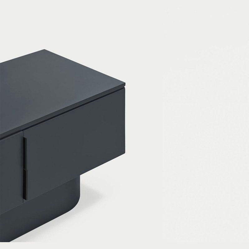 El Mueble TV Totem 4P es una mesa rectangular gris oscuro con un diseño elegante y minimalista, perfecta para una estética moderna sobre un fondo claro.