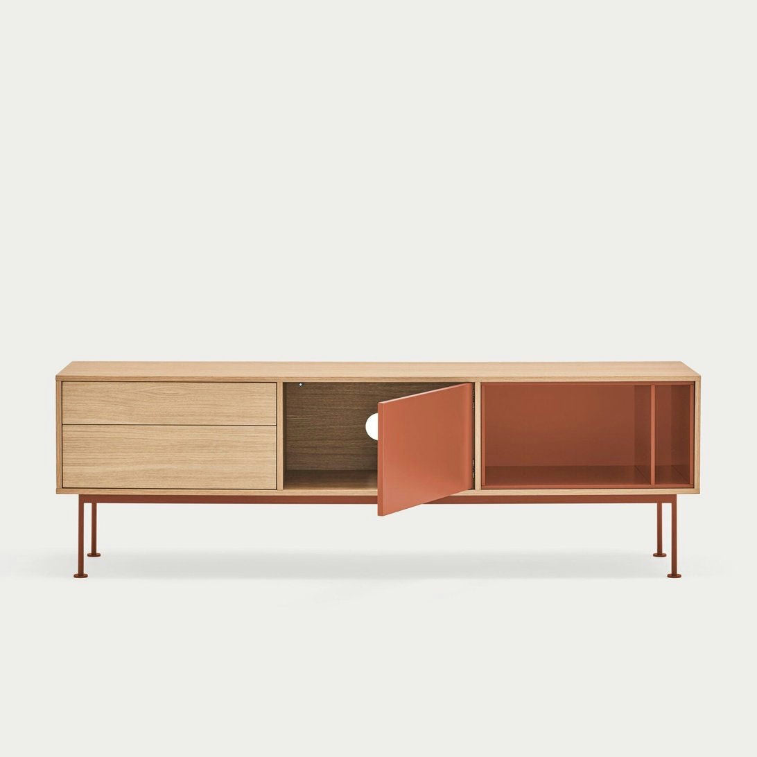El Mueble TV Yoko 1P2C es un aparador minimalista de madera con tres compartimentos, incluido uno con una puerta naranja parcialmente abierta y delgadas patas rojas, que encarna el diseño contemporáneo. Ofrece almacenamiento elegante y, al mismo tiempo, funciona como un elegante mueble para TV.