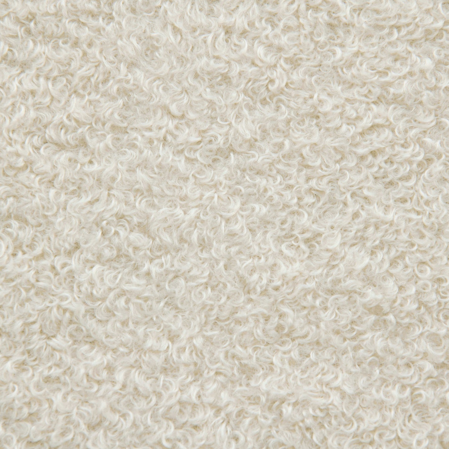 Primer plano de un tejido con textura rizada de color blanco roto que recuerda al vellón, ideal para el acogedor saco de espuma Om 135 Teddy, apto para exteriores.