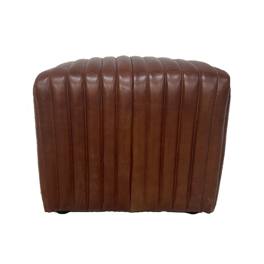 El Pouf cuadrado cuero marrón Bristol es un puf de cuero marrón, rectangular, con costuras verticales y que ofrece un elegante asiento adicional, fotografiado de frente sobre un fondo blanco.