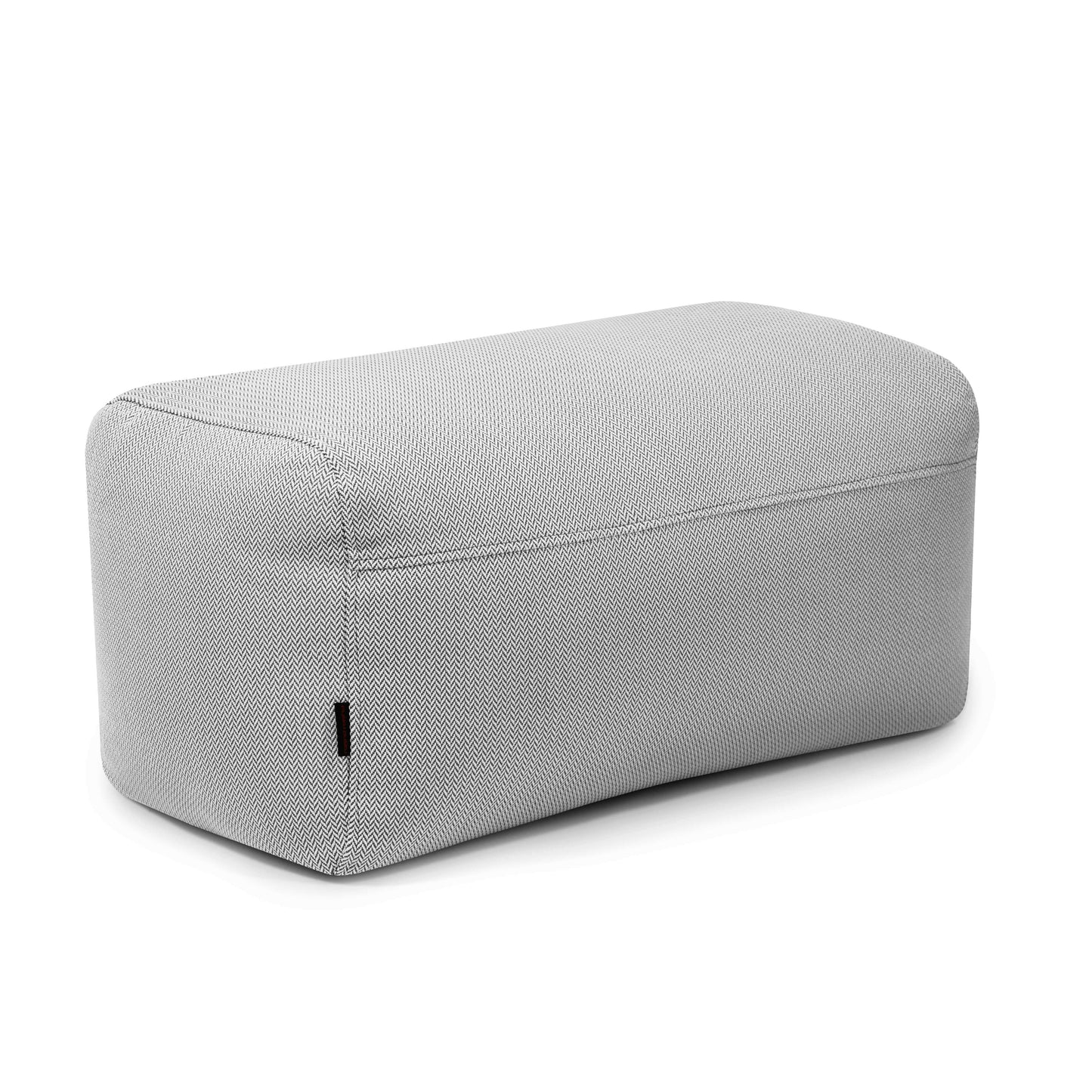 El Pouf Plus 100 Canaria, un puf rectangular tapizado en gris claro con bordes redondeados, es ideal como asiento ergonómico para jardín y uso exterior, mostrado sobre fondo blanco.