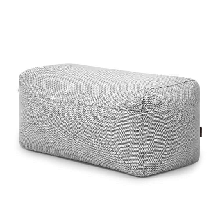 El Pouf Plus 100 Canaria es una otomana de exterior rectangular tapizada en gris claro con bordes redondeados, ideal como asiento para jardín, mostrada sobre fondo blanco.