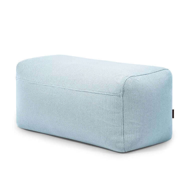 El Pouf Plus 100 Canaria es una otomana rectangular de color azul claro con tejido texturizado, diseñada para su uso en exteriores. Este ergonómico asiento para jardín se muestra sobre un fondo blanco liso.