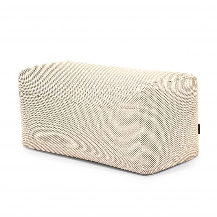 El Pouf Plus 100 Capri - uso exterior es una otomana rectangular de color beige con bordes redondeados y tejido texturizado, que ofrece apoyo ergonómico y estilo, mostrada sobre un fondo blanco liso.