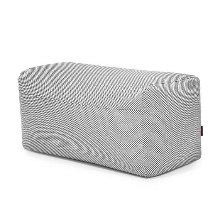 El Pouf Plus 100 Capri - uso exteriores es un banco tapizado rectangular y moderno con bordes redondeados y un sutil dibujo en blanco y negro que proporciona soporte ergonómico, mostrado sobre un fondo blanco.