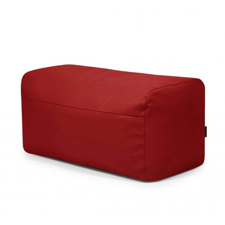 El Pouf Plus 100 Outside presenta un diseño rectangular rojo con tapicería lisa, sobre un fondo blanco, ideal para añadir un toque de color a su mobiliario de exterior.