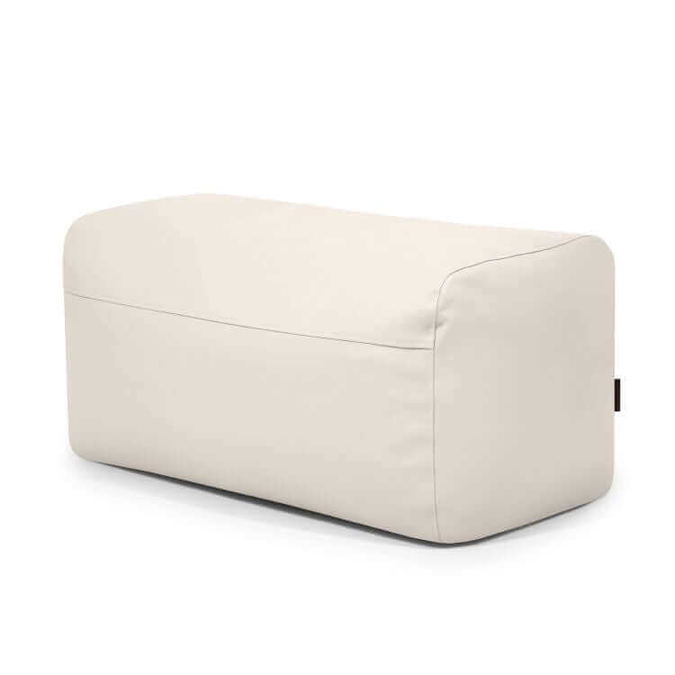 El Pouf Plus 100 Outside es un puf ergonómico rectangular de color beige claro con bordes lisos y redondeados y un suave cojín, ideal como mobiliario de exterior.