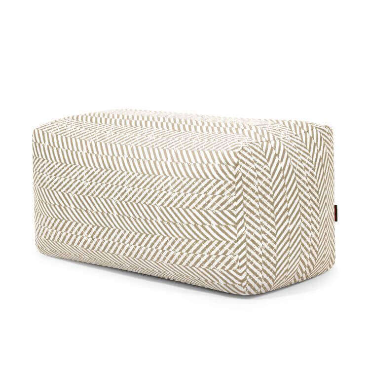 Pouf rectangular de tela estampada PLUS 100 ZARZUELA, compacto y ligero (100×60×45 cm), moderno para dormitorio o salón, con tapizado beige y blanco en espiga, ideal como soporte cómodo para piernas. Fondo blanco.