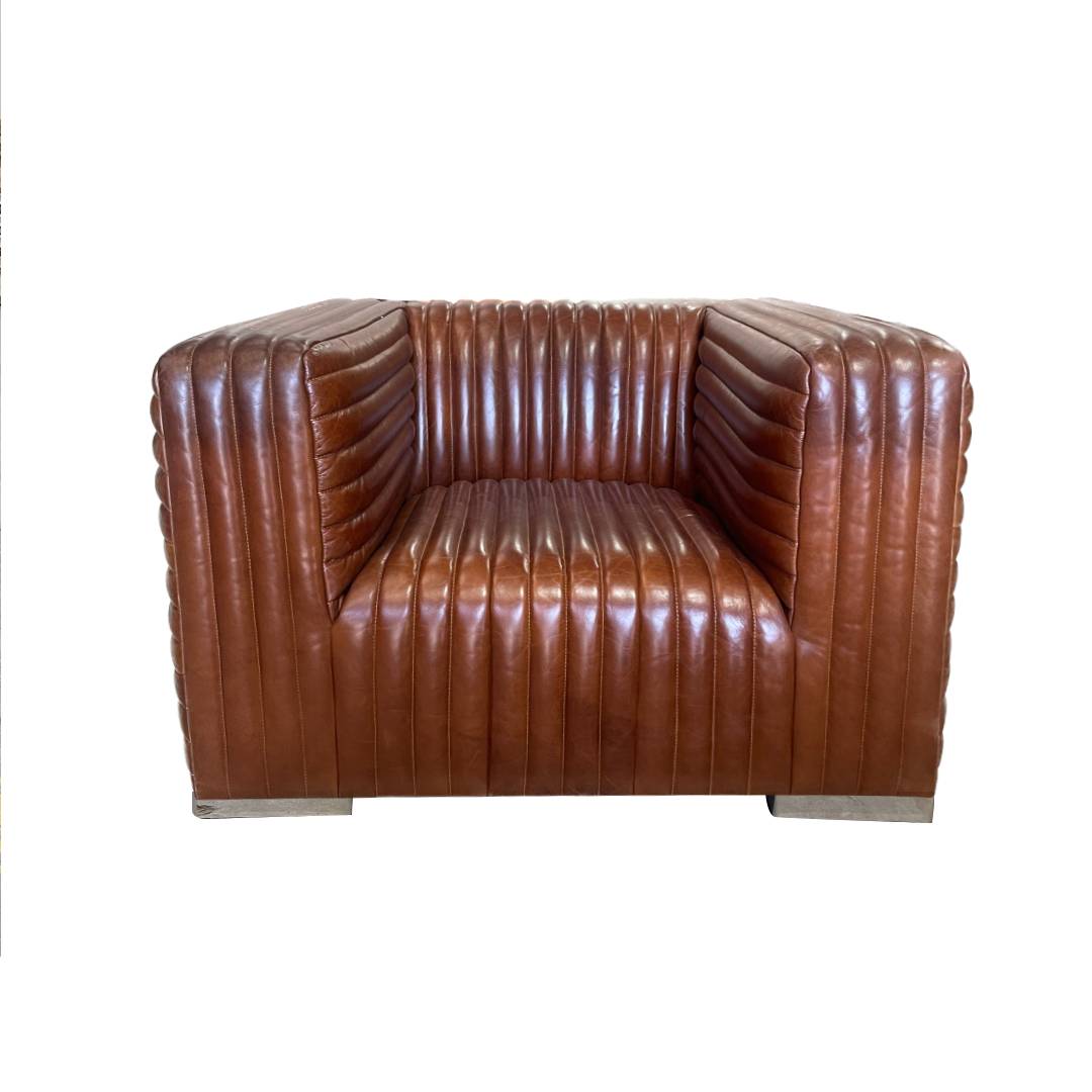 Sillón en Cuero y Madera Bristol, con tapizado acanalado vertical y diseño cuadrado en cuero marrón, ideal como sillón industrial moderno sobre fondo blanco.