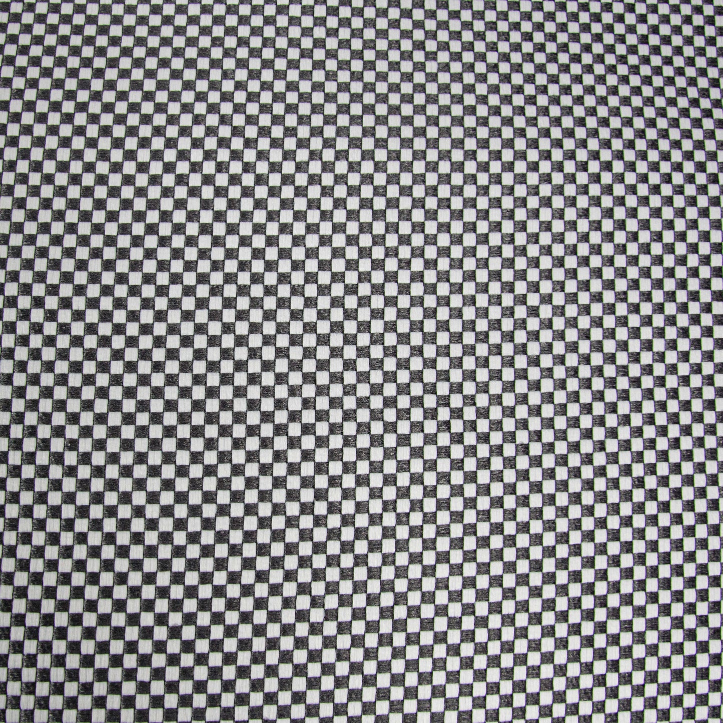 Un primer plano de un diseño a cuadros en blanco y negro, espaciado uniformemente y repetido por todo el Puff gigante redondo de tejido repelente al agua 135×135×50 cm - moderno - salón - ROLL 135 CAPRI.