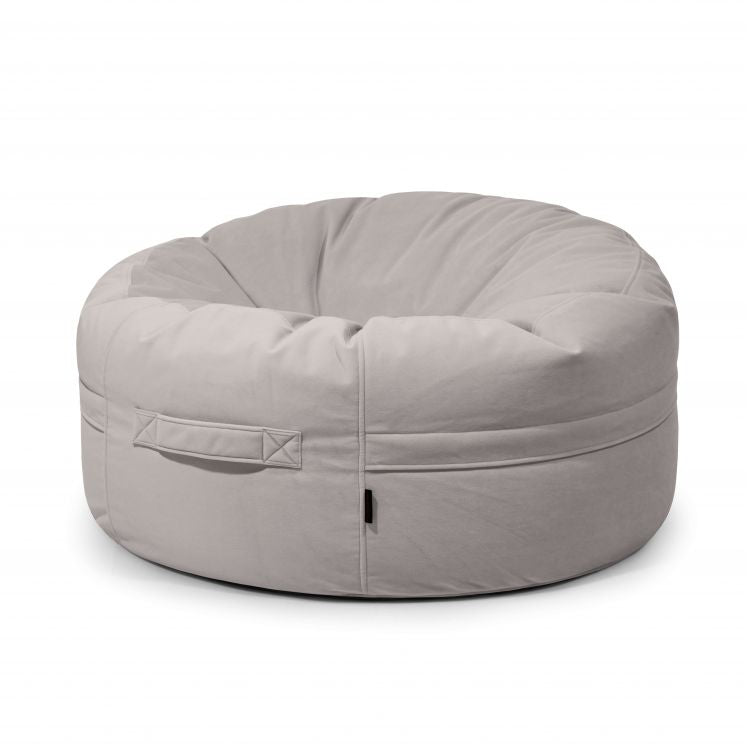 El Puff grande redondo de terciopelo velour 105×105×50 cm ROLL 105 BARCELONA, en gris claro y con asa lateral, es ideal para relajarse en cualquier hogar moderno de Barcelona. Perfecto para interiores.