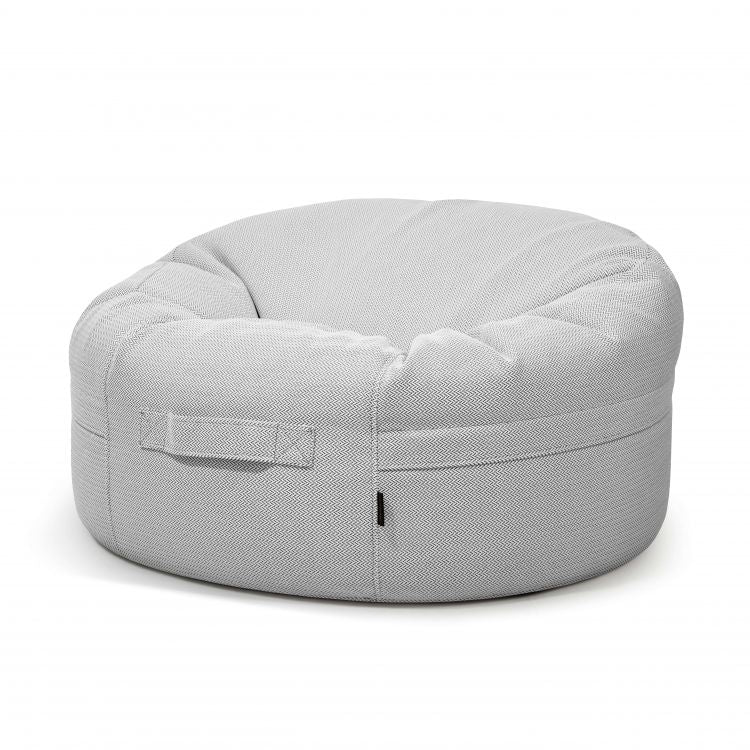 El Bean bag Roll 105 Canaria es un sillón redondo en forma de donut de color gris claro con un asa de tela en el lateral, diseñado para su uso en exteriores y que se muestra sobre un fondo blanco liso.
